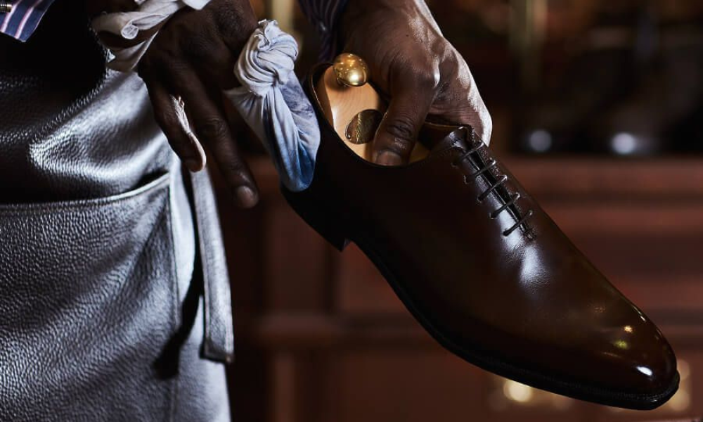man cleaning brown shoes